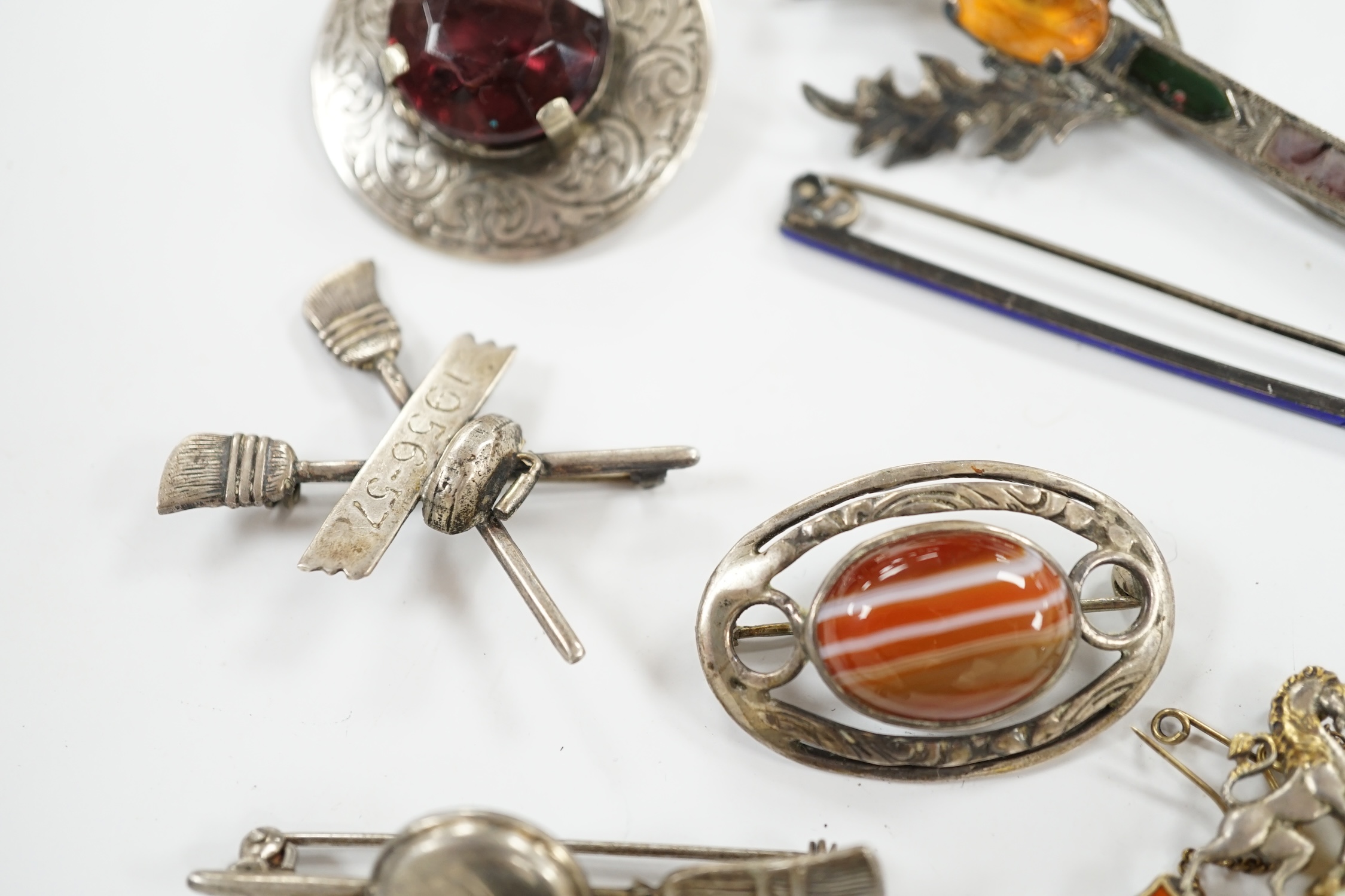 A 1950's Scottish silver, gem and Scottish hardstone set brooch, 91mm, together with six other brooches including four sterling and one silver. Condition - fair